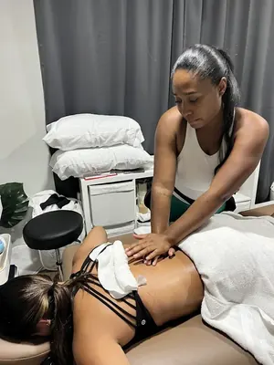 Maya Sharpe massaging a client's lower back in the treatment room
