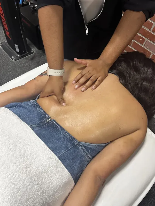 Maya Sharpe massaging a client's back with both hands