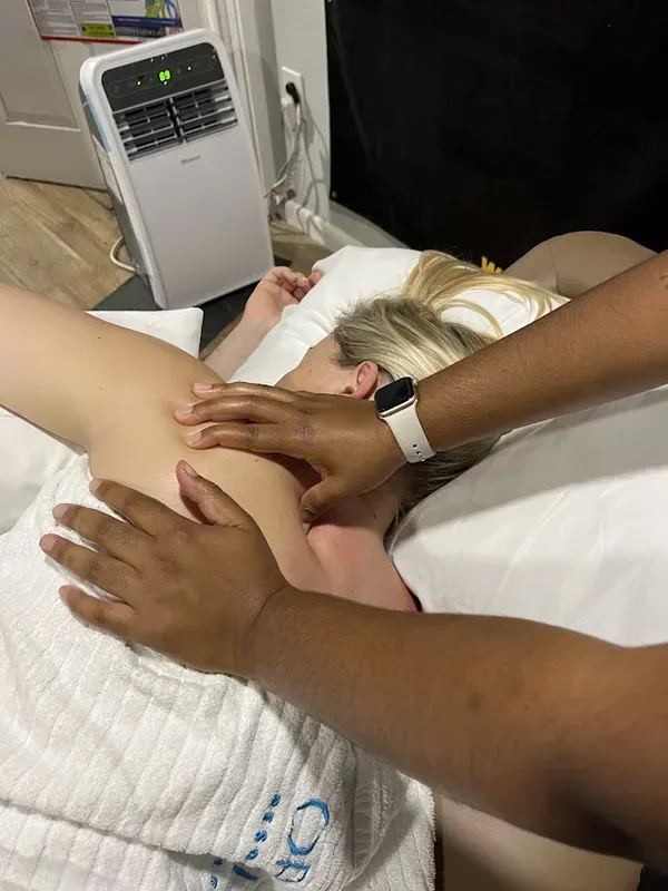 Close-up of Maya Sharpe's hands working a client's neck and shoulder
