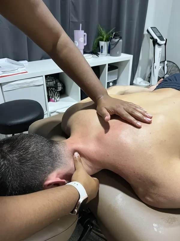 Hands working a client's neck and upper back